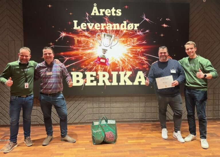 Fire menn foran et bilde som sier "årets leverandør Berika" som representerer utmerkelsen gitt av Gigaboks